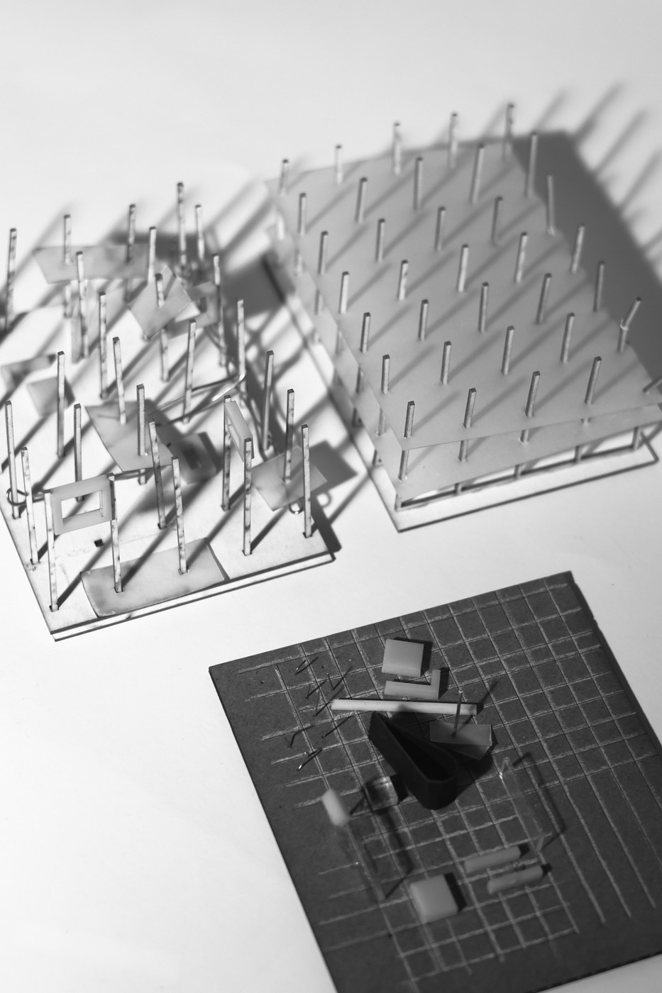 Two study models beside a detail model on a gridded board.